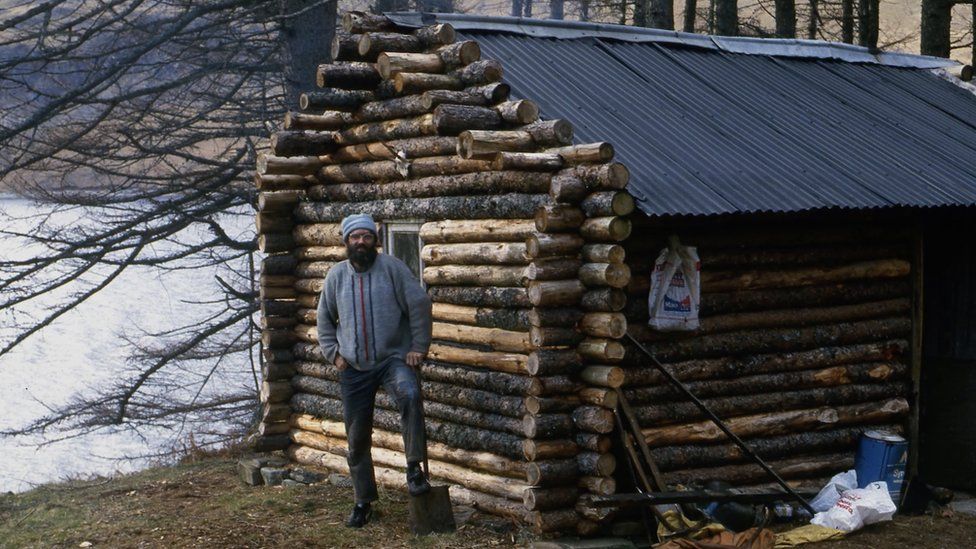 Ken with his log cabin soon after it was built in the early 1980s