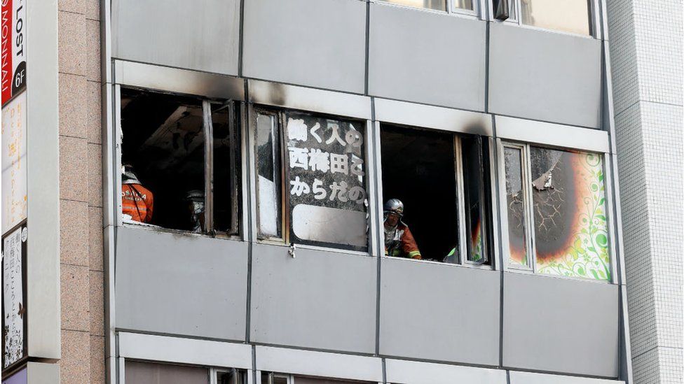 Firefighters work at the scene, where twenty-seven people were feared dead after a blaze at a building in Osaka, on 17 December 2021