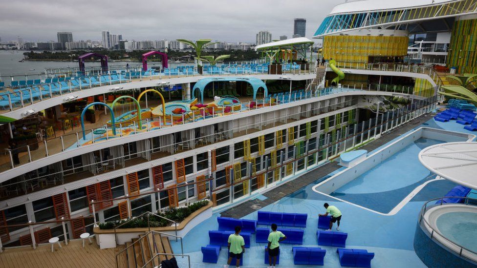 Workers place lounge chairs next to the Royal Bay pool onboard the Royal Caribbean Icon of the Seas cruise ship at PortMiami in Miami, Florida, US, on Thursday, Jan. 11, 2024.