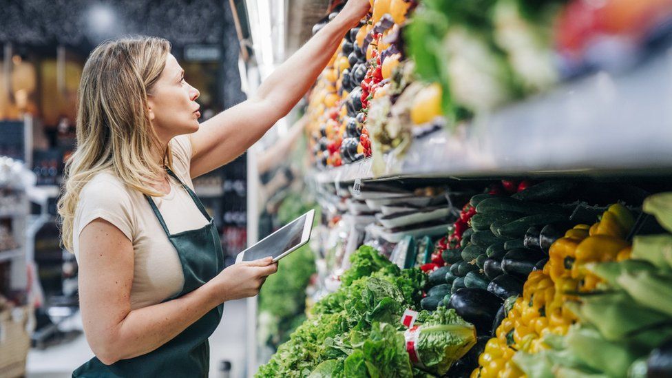 Supermarket worker looking at shelves