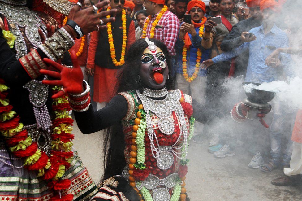 A person dressed as Hindu goddess Kali performs a dance during a religious procession during the Maha Shivratri festival in Allahabad, India
