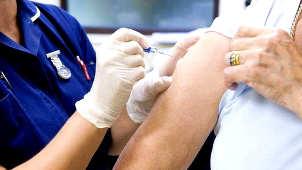 nurse giving flu jab