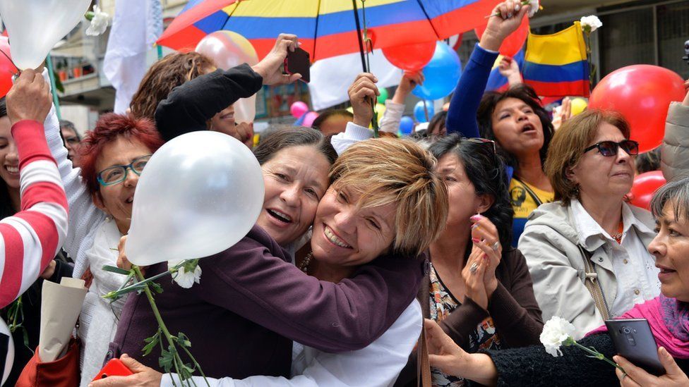 Colombians celebrate in downtown Bogota as they watch the signing of the ceasefire between the Government and the FARC guerrillas in Havana on a giant screen, on 23 June 2016