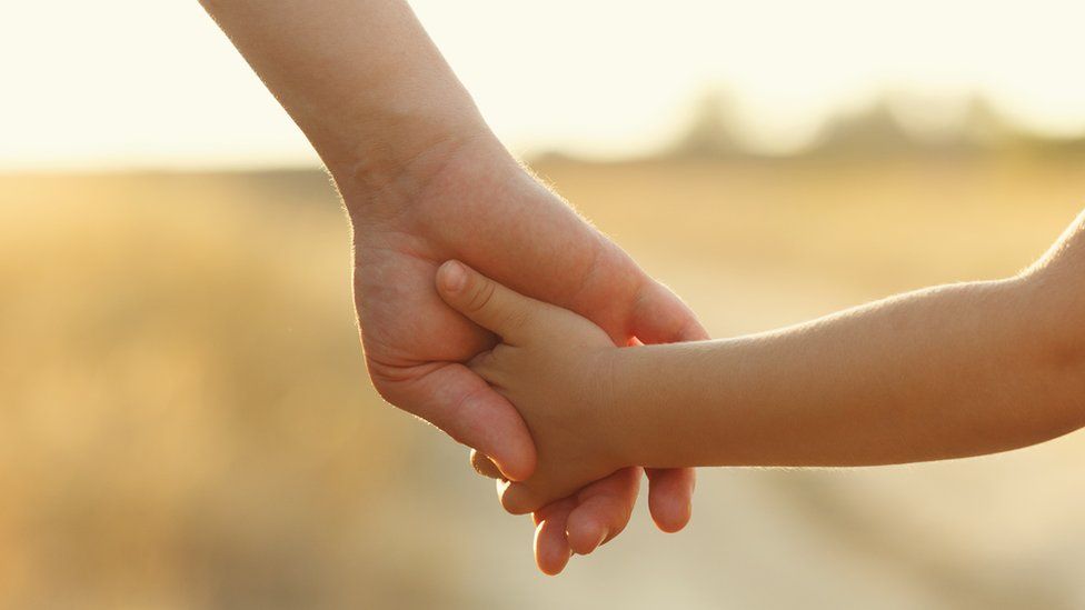Close-up shot of man holding hands with a young girl