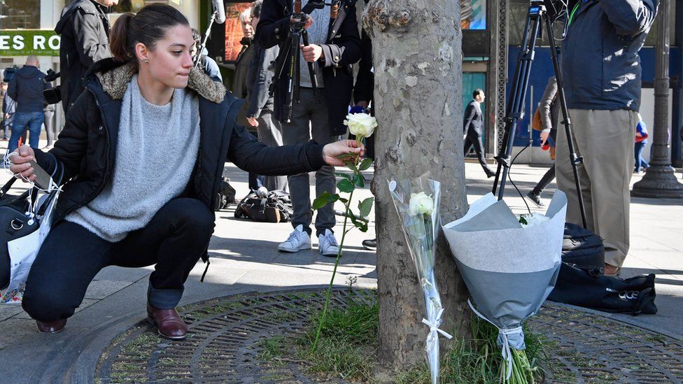 Woman lays a flower at the scene of the attack