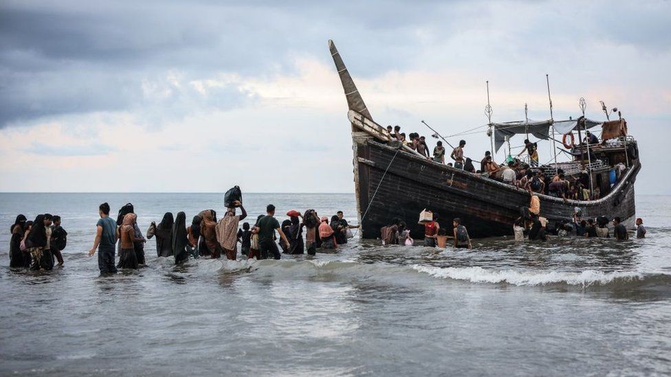 Rohingya refugees return to a boat after locals turn them away.