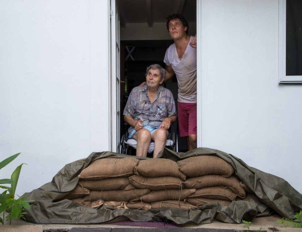 Parramatta Park resident John Irving and his son Steve look at the sky from their sandbagged doorway in Cairns, Queensland, on 15 December 2018.