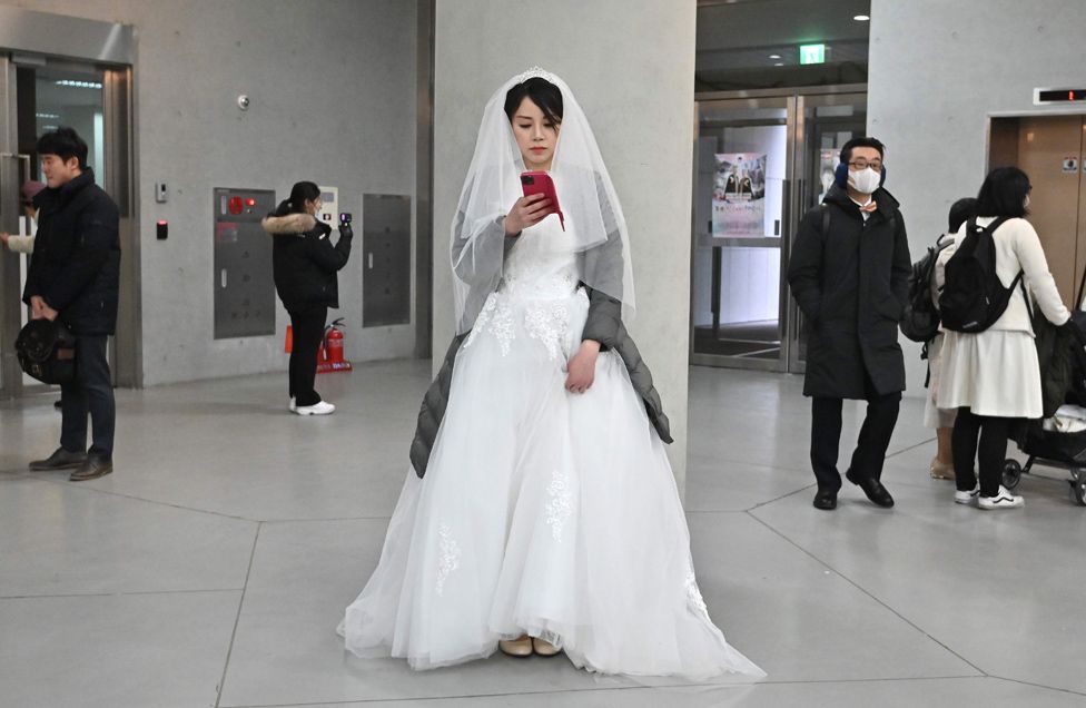 Bride takes a selfie at a mass wedding ceremony organised by the Unification Church in South Korea.