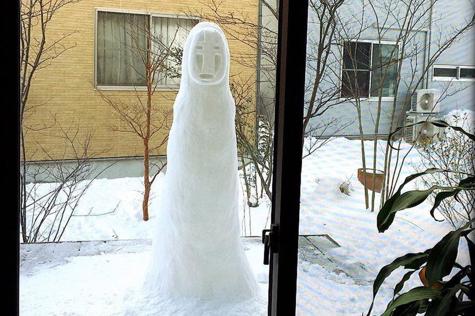 A tall snowman of No-Face, photographed through a window by Instagram user haruflower.beautytree.