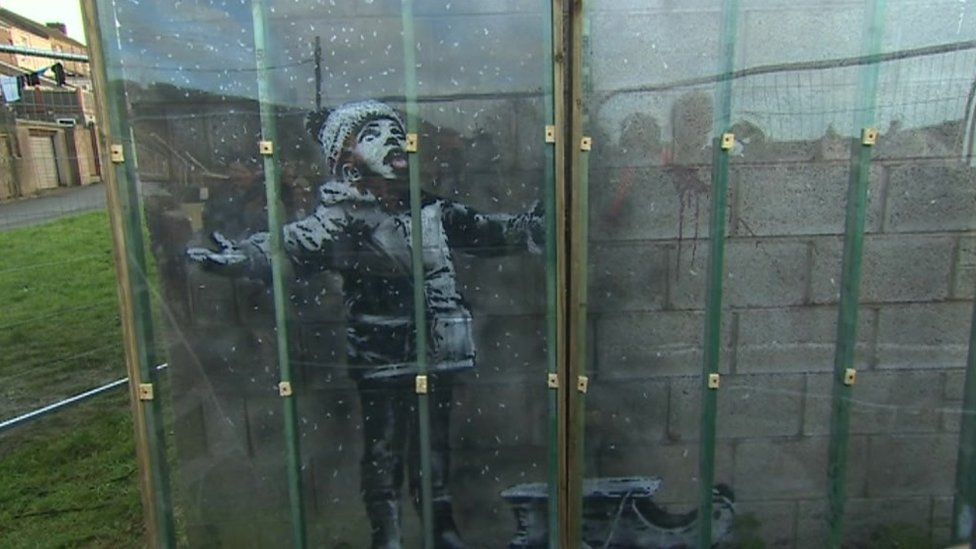 Plastic sheet being placed over the Banksy artwork in Port Talbot