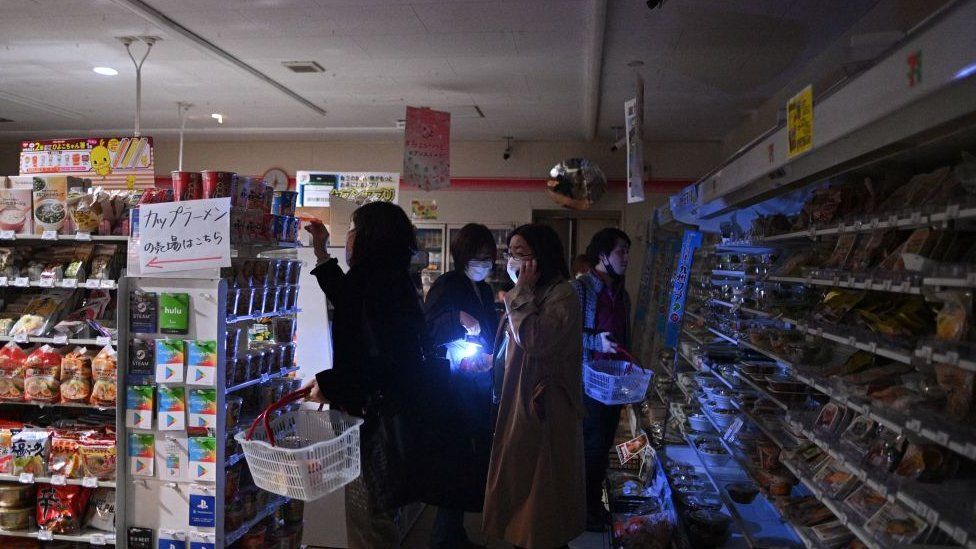 Gente comprando con antorchas en Tokio