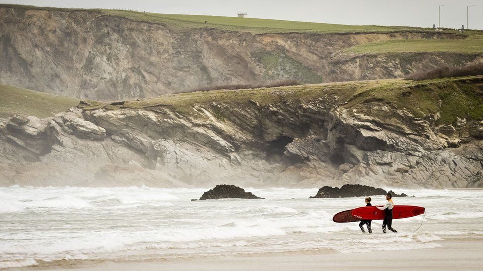 Surfers at a beach in Newquay, Cornwall