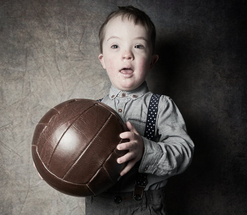 Isaac from Whitley Bay holds a large brown leather football
