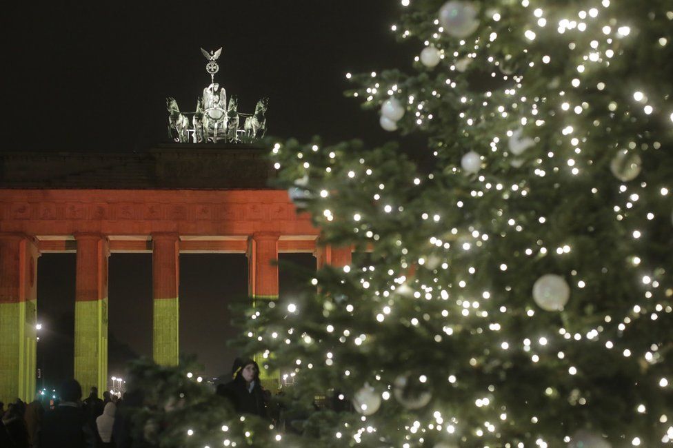 The Brandenburg Gate is illuminated in the colours of the German flag in Berlin, Germany, 20 December