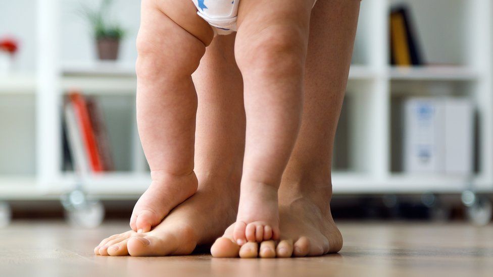 Toddler standing on mum's feet