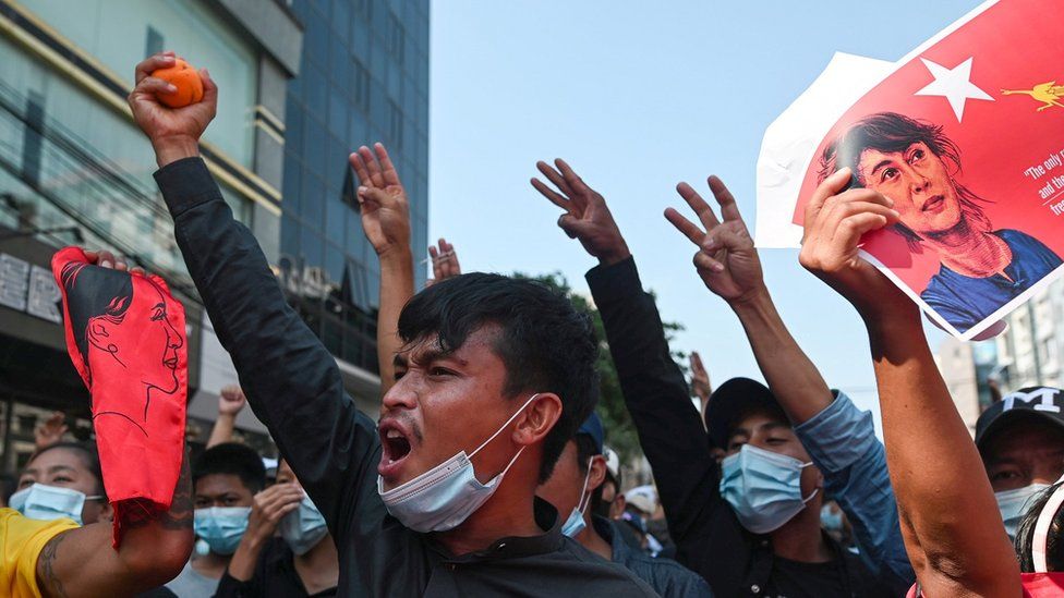 Люди показывают салют тремя пальцами во время митинга протеста против военного переворота, 8 февраля
