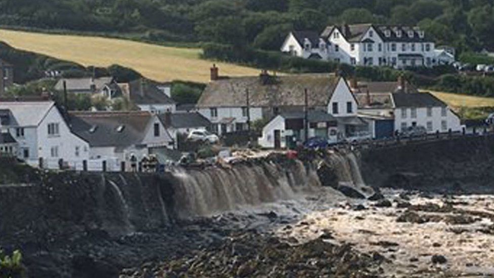 Flood water cascading over cliff at Coverack