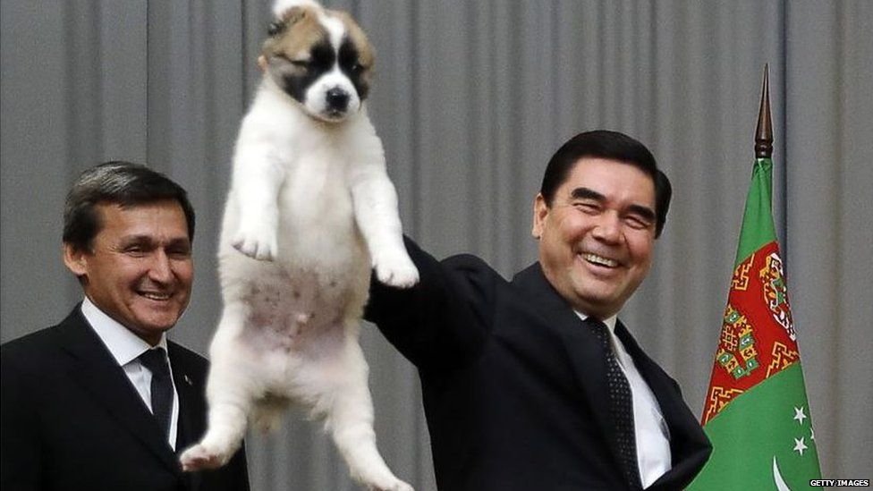 Turkmen leader holding a puppy by the neck