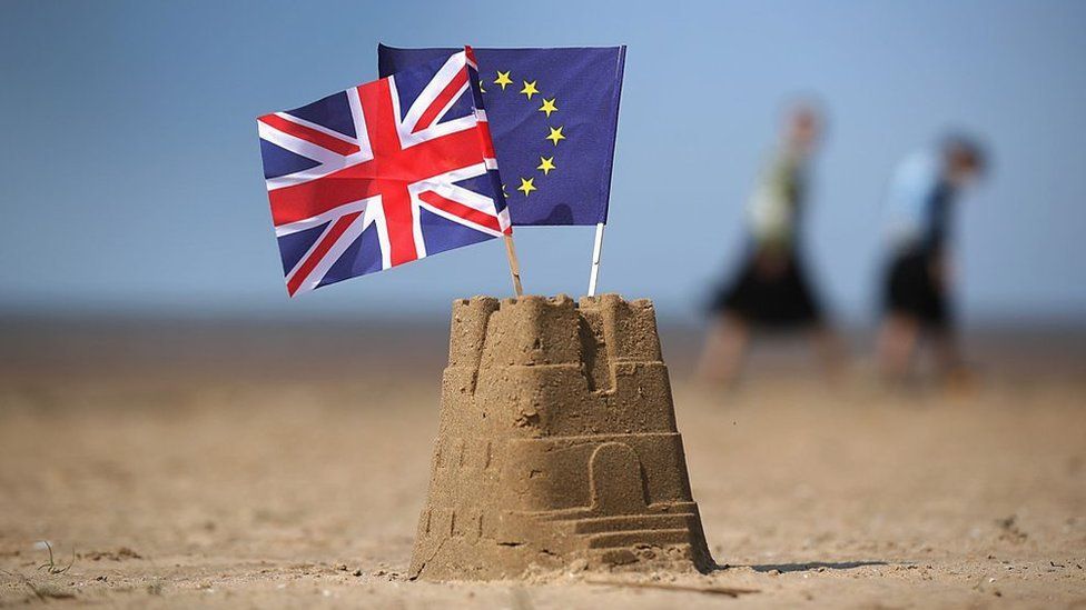 Sandcastle with Union flag and EU flag