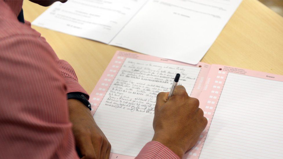 Anonymous student's hands writing an exam, file pic