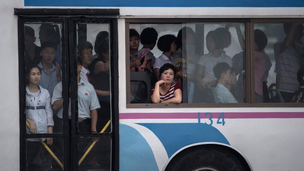 A commuter looks out from the window of a trolley bus tram in Pyongyang on 21 July