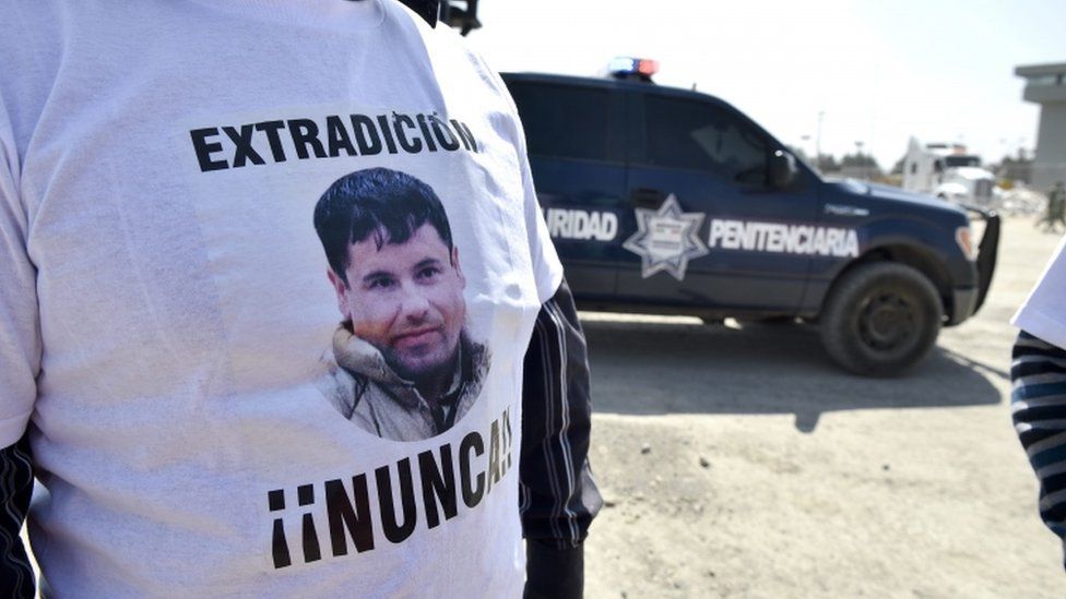 An assistant to Jose Luis Gonzalez Meza (not framed), who alleges to be lawyer of imprisoned Mexican drug lord Joaquin "El Chapo" Guzman, wears a t-shirt that reads "Extradition - Never!!" against the the extradition of El Chapo to the US in front of El Altiplano prison on February 24, 2016 in Almoloya de Juarez, Mexico. AFP
