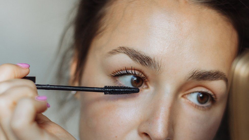 A girl applying mascara