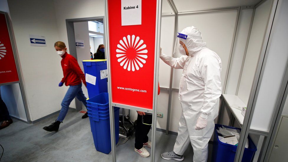 A medical worker collects a swab sample at Duesseldorf Airport