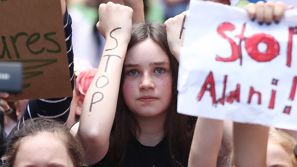 A girl protests in a crowd in Sydney for climate change action