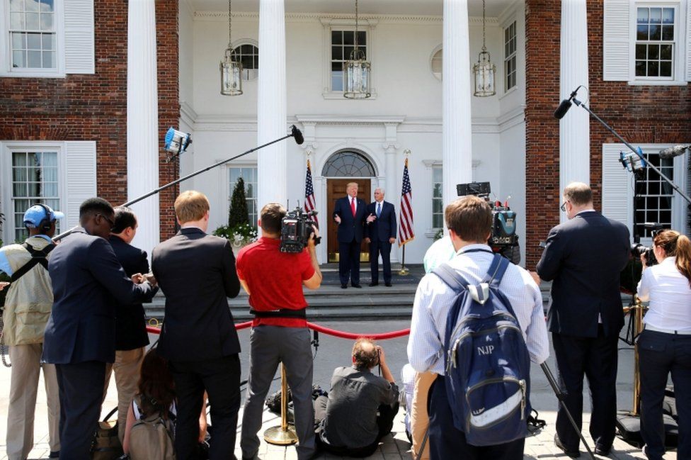 A velvet rope separates reporters from the man with the nuclear codes