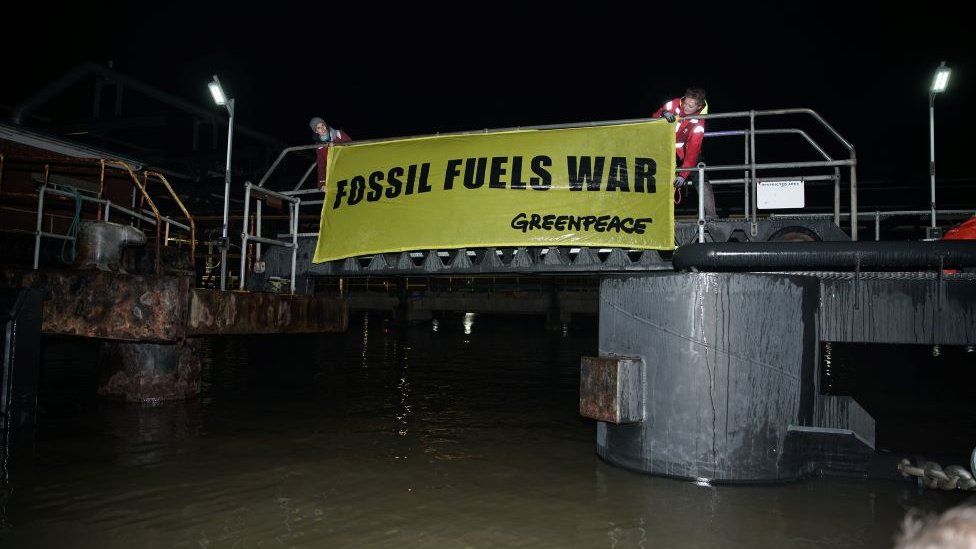 Greenpeace activists scale part of terminal in Grays with banner reading fossil fuels war