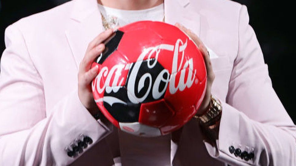 Man holding Coca-Cola branded football