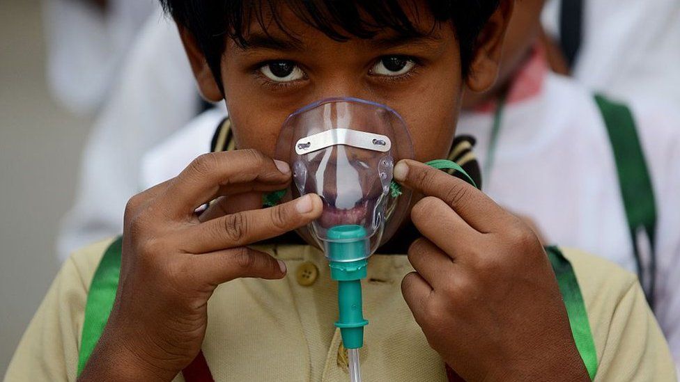 An Indian schoolchild adjusts his facemask before the start of an event to spread awareness of the problem of air pollution in New Delhi on June 4, 2015, on the eve of World Environment Day.