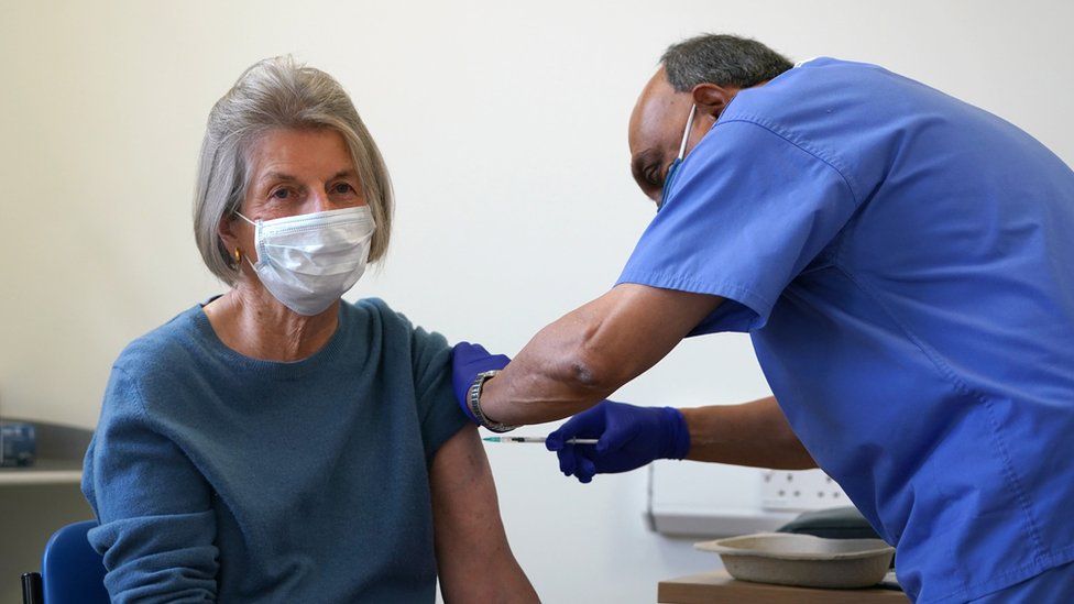 Woman being given a Covid vaccine by a doctor