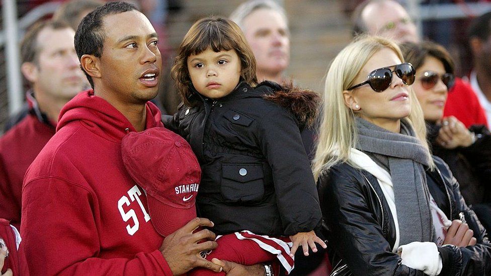 Tiger Woods holds his daughter Sam, alongside his then wife Elin Nordegren, in Palo Alto, California, in 2009