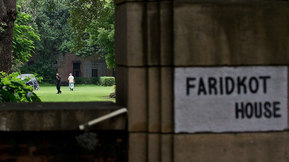 Indian men walk in premises of the Faridkot House complex in New Delhi on July 29, 2013.
