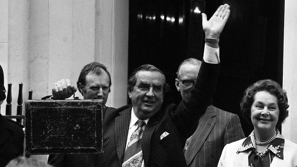 Chancellor of the Exchequer Denis Healey, holding the budget box and accompanied by his wife Edna, waves the crowd as they leave Number 11 (Eleven) Downing Street for the House of Commons where Mr Healey will present his budget