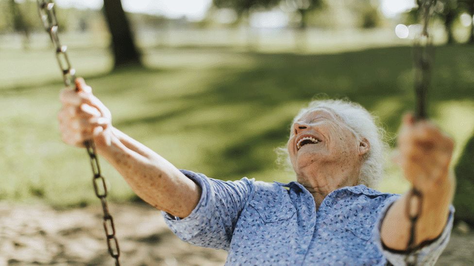 Elderly woman on a swing
