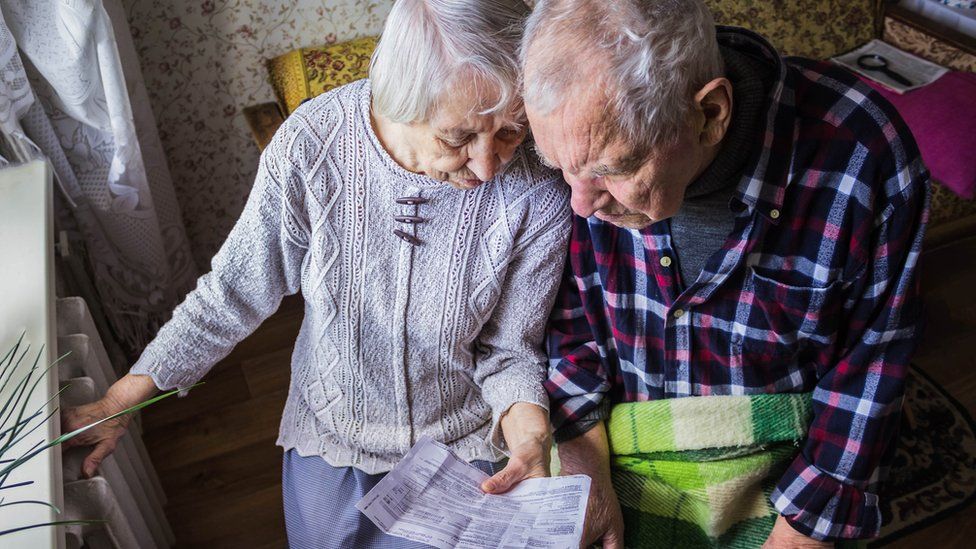An elderly couple by radiator