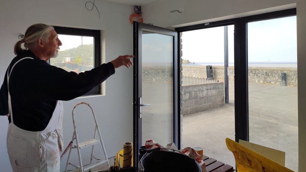 A volunteer painter working on the changing rooms