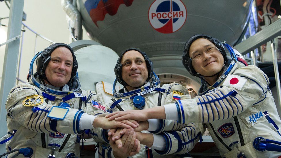 Members of latest International Space Station shake hands before last exam before setting up