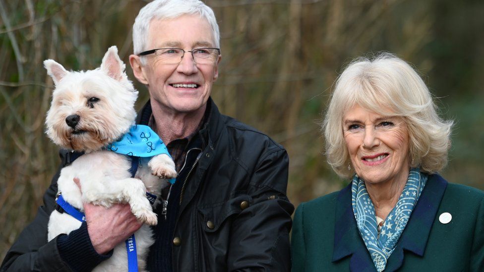 Camilla, Duchess of Cornwall, patron of Battersea Dogs and Cats Home and Battersea Ambassador Paul O’Grady on a brief woodland walk with a rescue dog which is yet to be re-homed, during her visit to Battersea Brand Hatch Centre on February 2, 2022 in Ash, England