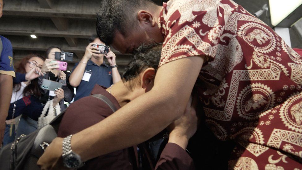 Pornsawan and his father hug outside the airport