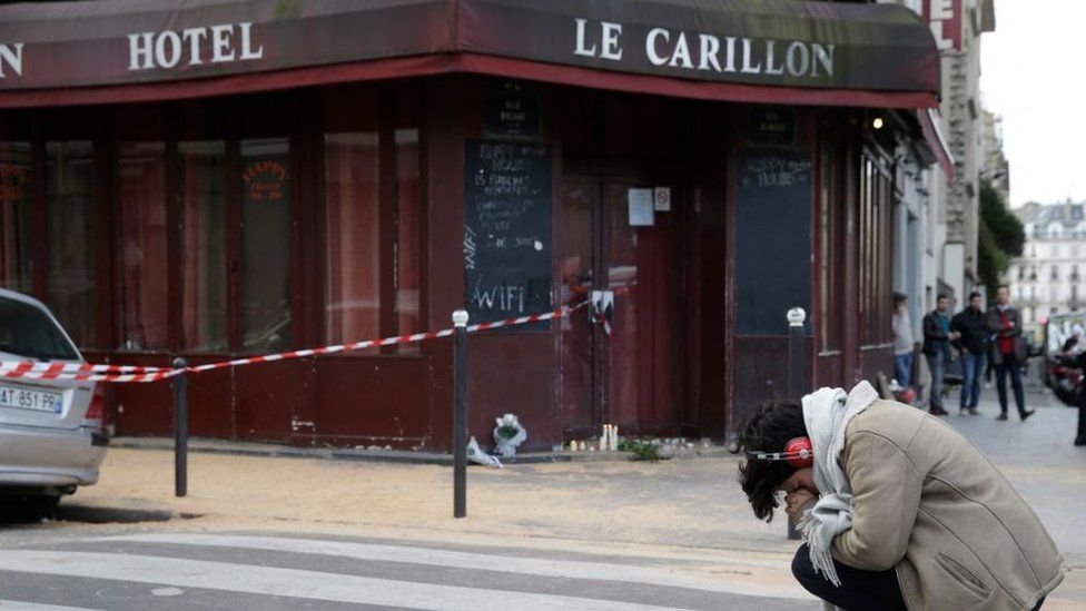 A woman mourns outside of the Carillon bar in the 10th district of Paris on November 14, 2015