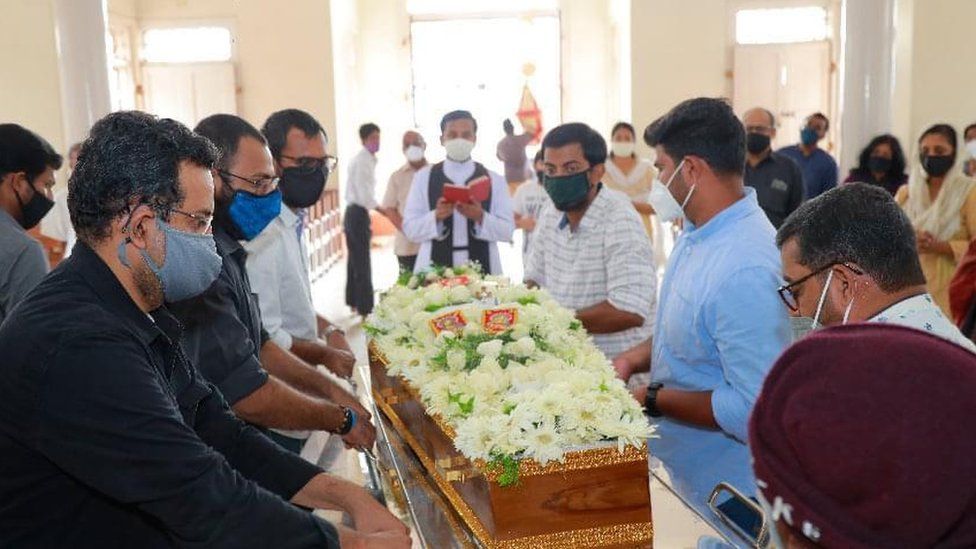 Родственники кладут гроб в церковь для погребального обряда