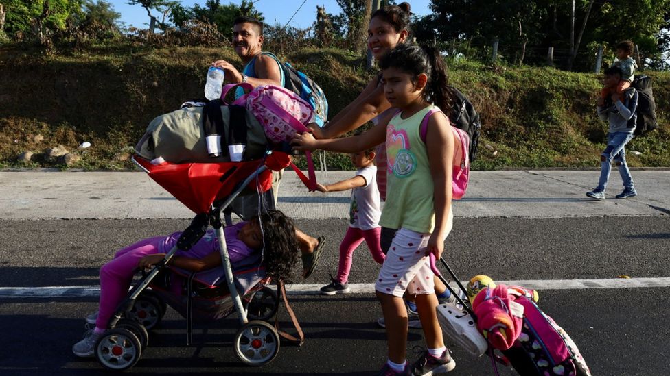 Migrants walk as they leave Tapachula in a caravan to attempt to reach the US border