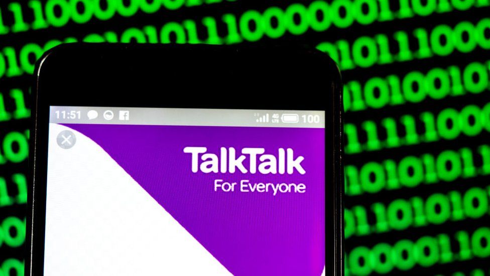 The talktalk logo is seen on a phone here against a background of green binary code in a photo illustration