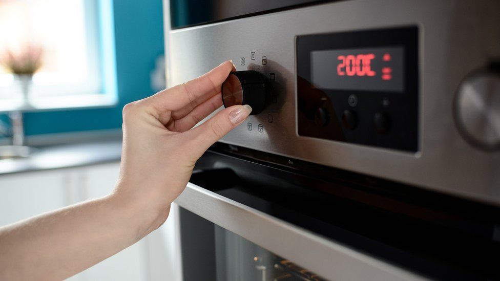 Woman turning oven on