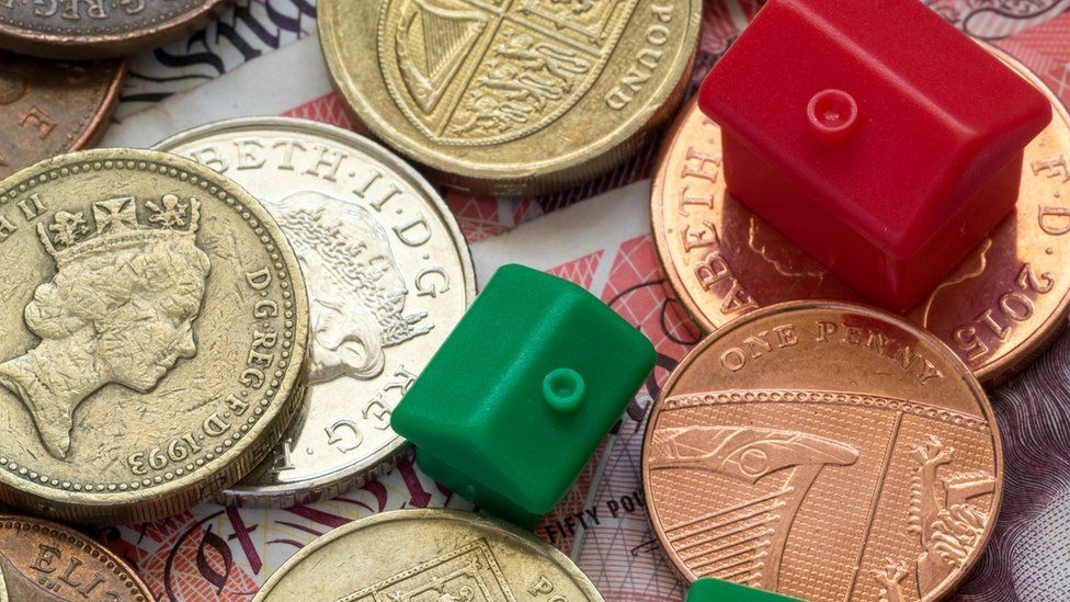 Monopoly houses and hotels on top of UK coins and banknotes