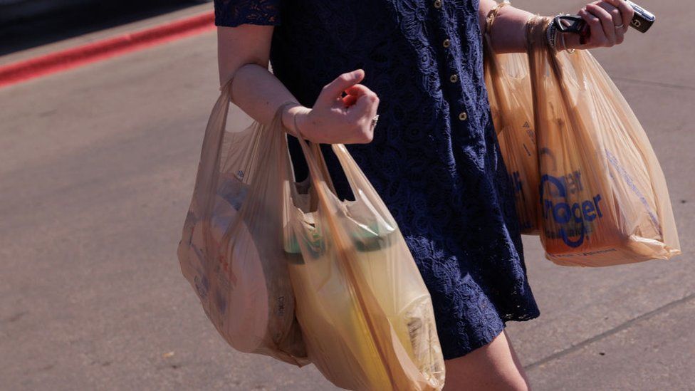 A shopper carries bags outside a Kroger grocery store in Dallas, Texas, US, on Wednesday, Feb. 21, 2024.